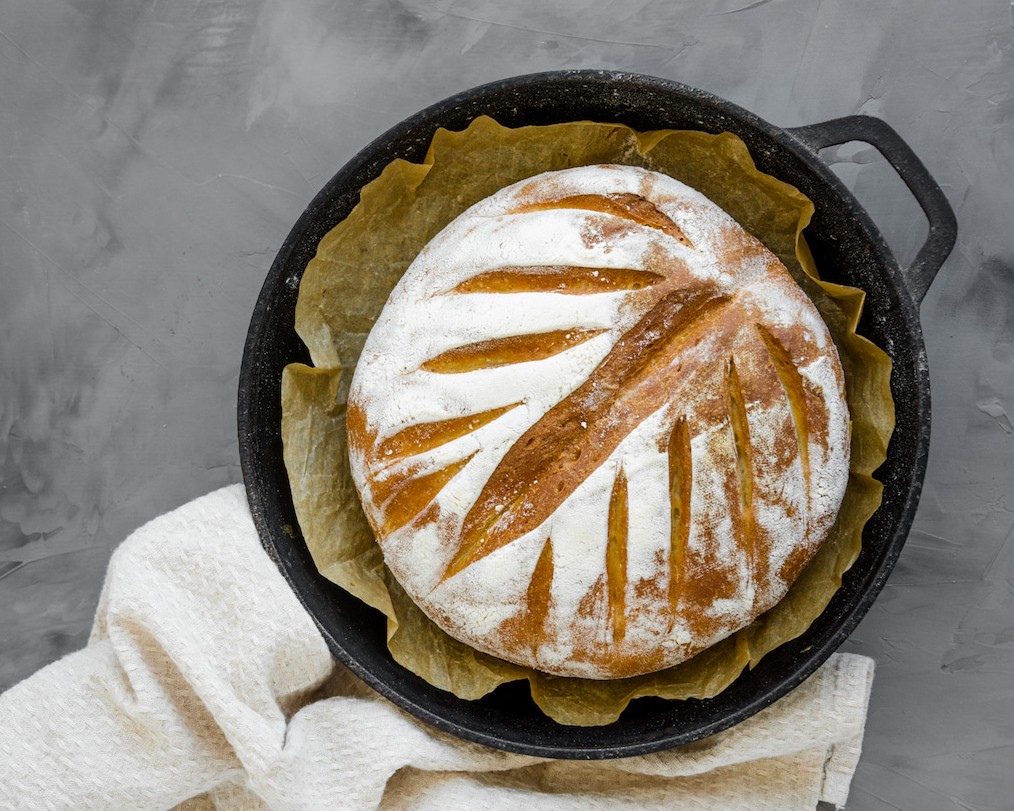Čerstvě upečený chléb v litinovém hrnci.